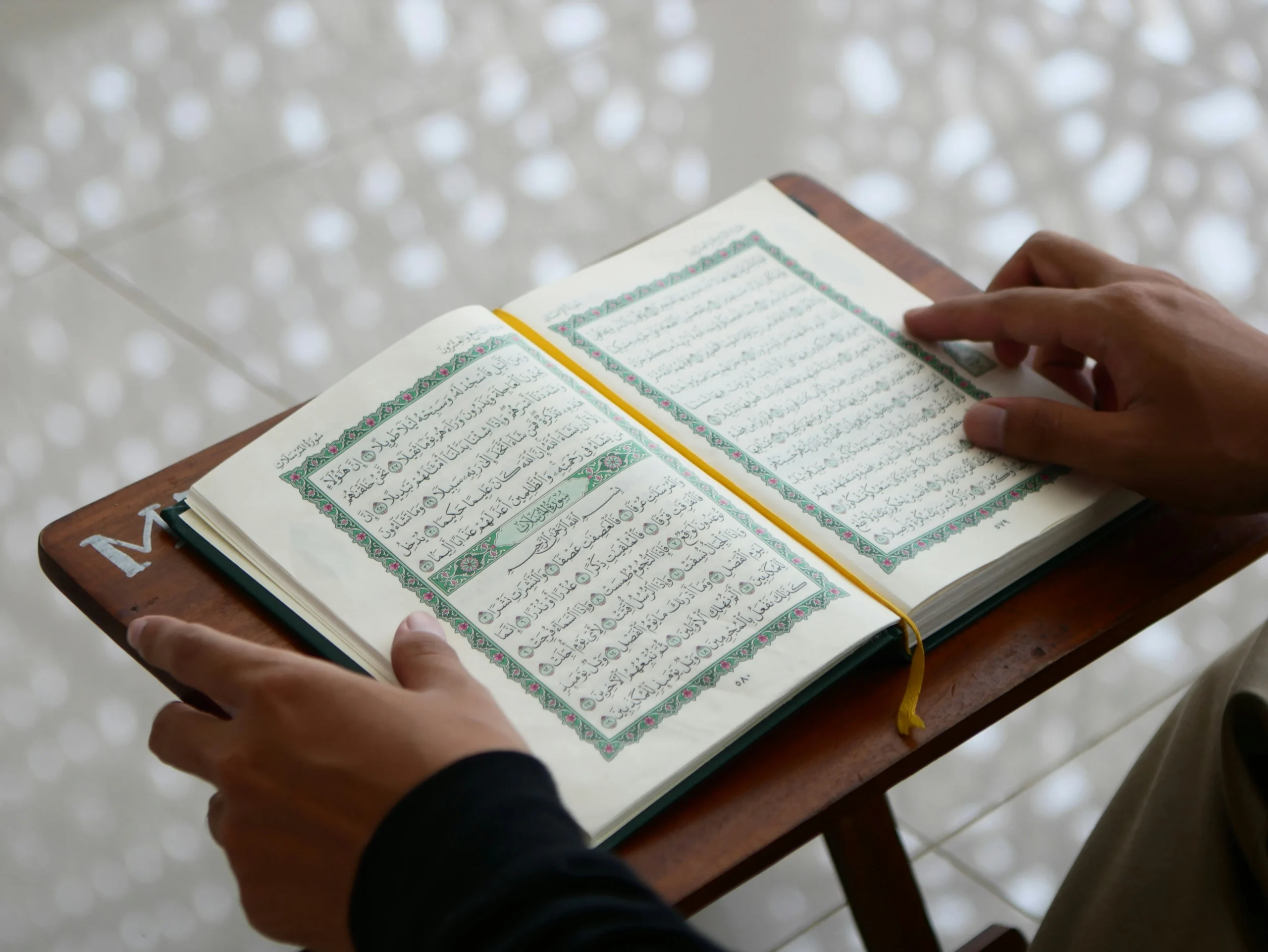 Student reading from an open Quran