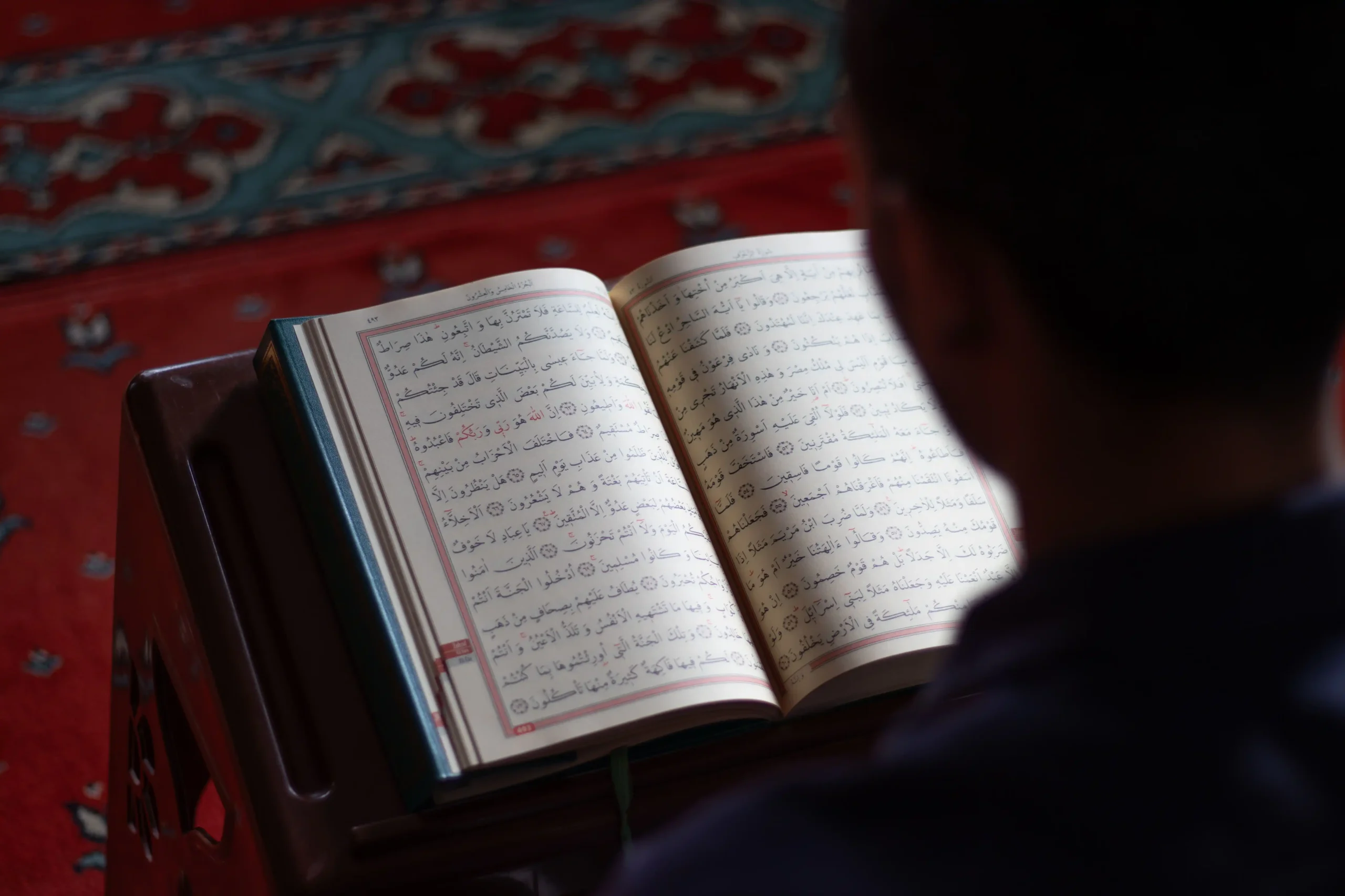 A learner following the Quran text while reading